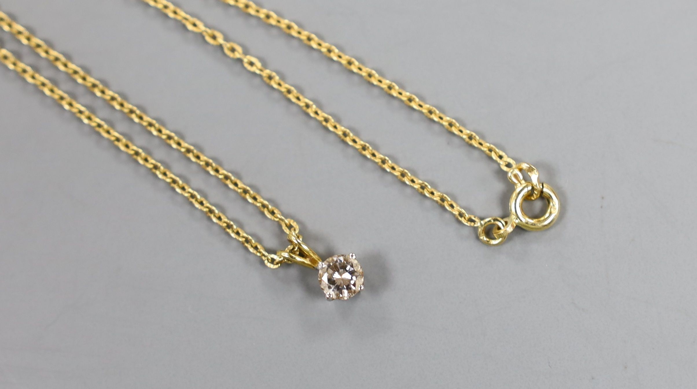 An 18ct gold and solitaire diamond set pendant, on an 18ct gold chain, chain 40cm, gross weight 2.7 grams.